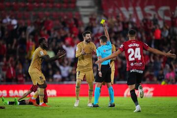 El árbitro Gil Manzano muestra la cartulina amarilla a Gerard Piqué.