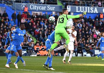 El jugador del Real Madrid, Varane, y el portero del Getafe, Soria, saltan hacia el balón en la jugada del 0-1.