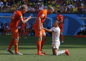 Alexis recrimina una entrada a los holandeses Dirk Kuyt (izquierda) y Ron Vlaar.