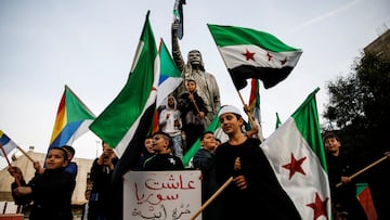 People celebrate next to a sculpture of Sultan Pasha al-Atrash, a Druze warrior who led a revolt against French rule in 1925, after Syrian rebels announced that they had ousted President Bashar al-Assad, in Majdal Shams, a Druze village in the Israeli-occupied Golan Heights, December 9, 2024. REUTERS/Shir Torem