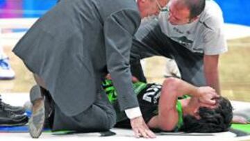 <b>DURO REVÉS. </b>El doctor Guillén atiende a Ricky Rubio sobre el parquet del Palacio Vistalegre.