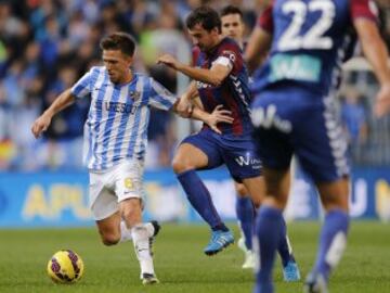 El centrocampista del Málaga Ignacio Camacho (i) trata de escapar de Mikel Arruabarena (2-i), del Eibar, durante el partido de Liga en Primera División que disputan esta noche en el estadio de La Rosaleda, en Málaga.