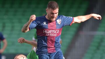 Real Betis&#039; Argentinian midfielder Guido Rodriguez (L) fights for the ball with Huesca&#039;s Spanish defender Javi Galan during the Spanish League football match between Real Betis and SD Huesca at the Benito Villamarin stadium in Seville on May 16,