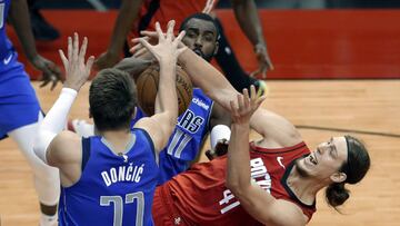 Apr 7, 2021; Houston, Texas, USA; Houston Rockets forward Kelly Olynyk (41) falls as he battles for a rebound with Dallas Mavericks guard Luka Doncic (77) and forward Tim Hardaway Jr. (11) during the second half of an NBA basketball game at Toyota Center. Mandatory Credit: Michael Wyke/POOL PHOTOS-USA TODAY Sports