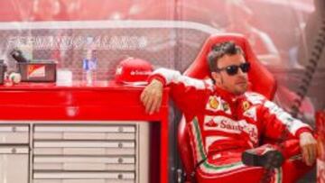 Alonso descansa en el box del equipo Ferrari.