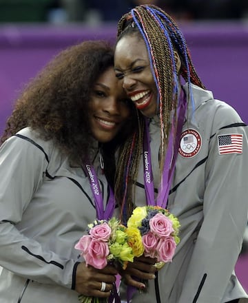 Serena Williams, left, and Venus Williams of the United States laugh together on the podium after receiving their gold medals in women's doubles at the 2012 Summer Olympics at the All England Lawn Tennis Club in Wimbledon, London.