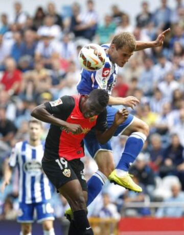 El delantero de Burkina Faso de la UD Almería Jonathan Zongo (i) lucha un balón con el centrocampista del Deportivo de la Coruña Álex Bergantiños, durante el partido de la sexta jornada de Liga de Primera División, disputado esta tarde en el estadio de Riazor.
