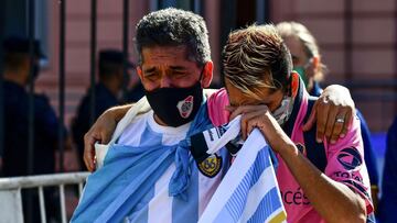 Fans mourn outside the Casa Rosada government house as they wait to pay tribute to Argentinian late football legend Diego Armando Maradona in Buenos Aires, on November 26, 2020. - Argentine football legend Diego Maradona will be buried Thursday on the outskirts of Buenos Aires, a spokesman said. Maradona, who died of a heart attack Wednesday at the age of 60, will be laid to rest in the Jardin de Paz cemetery, where his parents were also buried, Sebastian Sanchi told AFP. (Photo by RONALDO SCHEMIDT / AFP)