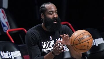 Brooklyn Nets guard James Harden, who has been out with a hamstring injury, takes the ball from a trainer while warming up before Game 5 of the team's second-round NBA basketball playoff series against the Milwaukee Bucks, Tuesday, June 15, 2021, in New York. (AP Photo/Kathy Willens)