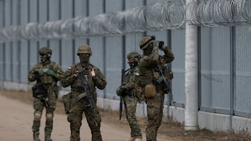 Polish soldiers and members of the Polish border guard patrol along the barrier on the Polish-Belarusian border in Ozierany Male, Poland, March 22, 2025. REUTERS/Kuba Stezycki