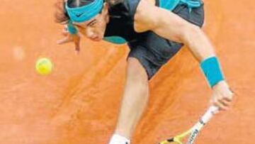 <b>DERRAPANDO. </b>Rafa Nadal derrapa sobre la tierra buscando una bola cercana a la red.