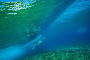 La surfista sudafricana Rosie Hodge nadando bajo el mar. 