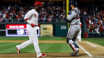 Philadelphia Phillies&#039; Andrew McCutchen, left, scores past Atlanta Braves catcher Brian McCann after Rhys Hoskins was walked with the bases loaded by relief pitcher Max Fried during the fifth inning of a baseball game, Sunday, March 31, 2019, in Philadelphia. (AP Photo/Matt Slocum)