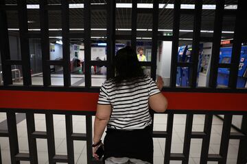 Una mujer espera cerca de una puerta en una estación de metro mientras las operaciones se reanudan parcialmente.