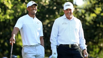 (FILES) In this file photo taken on April 3, 2018, Tiger Woods and Phil Mickelson, of the United States, talk on the 11th hole during a practice round prior to the start of the 2018 Masters Tournament at Augusta National Golf Club in Augusta, Georgia. - Former world number one Tiger Woods and defending champion Phil Mickelson were both named in the field for next week's PGA Championship on Monday. (Photo by Andrew Redington / GETTY IMAGES NORTH AMERICA / AFP)