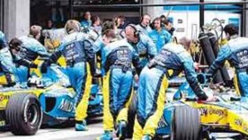 <b>RETIRADOS. </b>Los mecánicos de Renault empujan los monoplazas de Alonso y Fisichella para entrar en boxes tras su abandono.