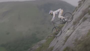 El piloto brit&aacute;nico de MTB Gee Atherton descendiendo con su bici por unas rocas muy empinadas. 