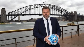 Australia&#039;s football coach Ange Postecoglou holds a football as he poses for a photo in front of the Sydney Harbour Bridge on September 27, 2017.
 Injured captain Mile Jedinak was on September 27 ruled out of Australia&#039;s crunch World Cup play-of