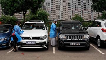 Lab technicians from the Mullah Laboratories perform COVID-19 swab tests at a drive through testing spot in Flower Hall parking, at Wits University, Braamfontein, Johannesburg, on January 5, 2021. (Photo by Luca Sola / AFP)