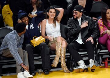 La modelo Kendall Jenner y su pareja el rapero Bad Bunny charlan con unos amigos durante el sexto encuentro de la semifinal. 