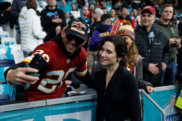La presidenta de la Comunidad de Madrid, Isabel Díaz Ayuso posa junto a varios aficionados en el Estadio Santiago Bernabéu. 