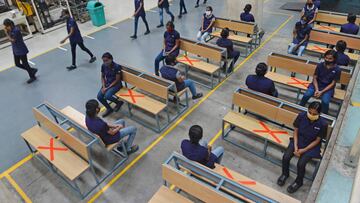 This picture taken on June 9, 2020 shows workers sitting while maintaining social distancing at an assemble unit of Royal Enfield motorcycle factory after the government eased a nationwide lockdown imposed as a preventive measure against the COVID-19 coro