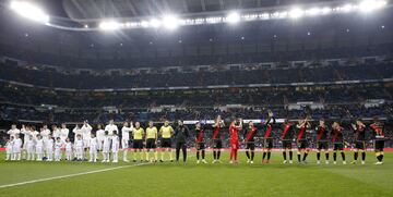 Los jugadores del Real Madrid y el Rayo Vallecano saludan a la afición en el centro del campo.