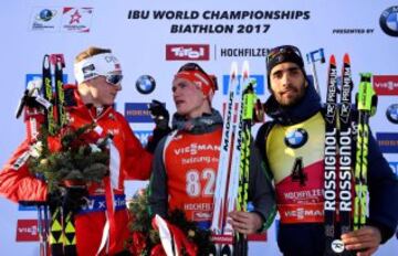 En el centro, Benedikt Doll de Alemania, ganador de la prueba, con Johannes Thingnes Boe de Noruega y Martin Fourcade de Francia.