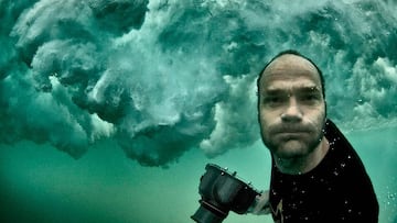 Timo Jarvinen bajo el agua, con una ola rompiendo sobre él y su cámara de fotos