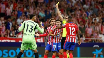 MADRID, 25/08/2024.- El árbitro Martínez Munuera (2-d) muestra la tarjeta amarilla al portero Paulo Gazzaniga (i), del Girona, durante el partido de la segunda jornada de Liga de Primera División que Atlético de Madrid y Girona FC disputan este domingo en el Civitas Metropolitano, en Madrid. EFE/Mariscal