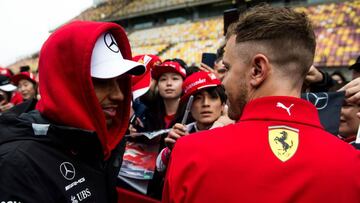 Mercedes' British driver Lewis Hamilton (L) and Ferrari's German driver Sebastian Vettel meet whilst signing autographs prior to the Formula One Chinese Grand Prix in Shanghai on April 12, 2018. / AFP PHOTO / Johannes EISELE