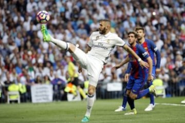 El delantero francés del Real Madrid Karim Benzema  controla el balón ante el defensa del Barcelona Sergi Roberto