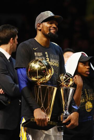 Kevin Durant con el trofeo Larry O'Brien y con el trofeo Bill Russell que le acredita como MVP de las Finales.