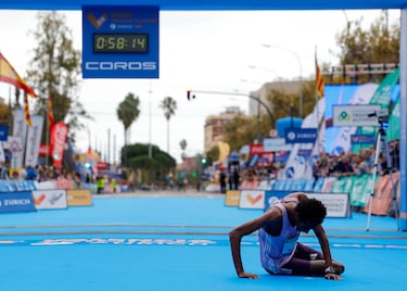Yomif Kejelcha cae al suelo tras pasar la línea de meta del Medio Maratón Valencia Trinidad Alfonso.