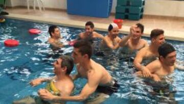 Los jugadores del Villarreal B se bañan, juegan y se divierten en la piscina en una actividad con personas con parálisis cerebral de la Asociación Aspropace.
