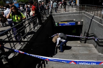 Un trabajador del metro pasa por debajo de una cinta de barricada para entrar en la estacin de metro de Legazpi, despus de que el metro fuera cerrado durante un corte de energa, en Madrid, Espa?a.