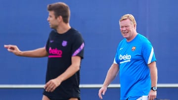 GRAFCAT7261. BARCELONA, 13/09/2021.- El entrenador del FC Barcelona, Ronald Koeman (c), junto al jugador Gerard Piqu&eacute; (i), durante el entrenamiento que el equipo azulgrana ha realizado este lunes en la Ciudad Deportiva Joan Gamper, previo al partid