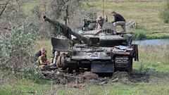 Ukrainian servicemen work on a tank on September 20, 2022, abandoned by Russian troops during their retreat in the north of the Kharkiv region. (Photo by SERGEY BOBOK / AFP) (Photo by SERGEY BOBOK/AFP via Getty Images)