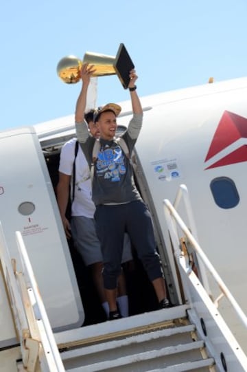 Los campeones de la NBA disfrutaron del viaje de vuelta a Oakland sin perder de vista el preciado trofeo Larry O'Brien. Stephen Curry.