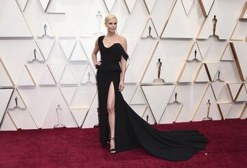 Charlize Theron, nominada al Oscar a la mejor actriz por 'El escándalo', posa con un vestido negro de dos piezas de Dior, con un solo hombro, gran abertura y cola.