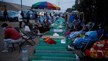 FILE PHOTO: Gente espera junto a tanques de ox&iacute;geno vac&iacute;os para llenarlos para los pacientes que sufren de la enfermedad del coronavirus (COVID-19), fuera de un proveedor de ox&iacute;geno privado, en Lima, Per&uacute;. 25 de febrero de 2021. REUTERS/Sebasti&aacute;n Casta&ntilde;eda/File Photo