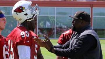 El nuevo defensive end de los Arizona Cardinals, Rodney Gunter (#95), recibe instrucciones del entrenador de línea defensiva del equipo, Brentson Buckner.
