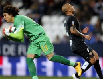 El portero mexicano del Málaga CF Francisco Guillermo "Ochoa" atrapa el balón ante el delantero brasileño Rafael Martins, del Levante, durante el encuentro de la ida de octavos de final de la Copa del Rey que ambos equipos disputan esta noche en el estadio de La Rosaleda. 