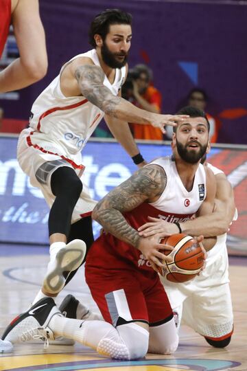 El escolta de la selección turca de baloncesto Goksenin Koksal intenta avanzar con el balón ante la oposición de los jugadores españoles Ricky Rubio y Marc Gasol.