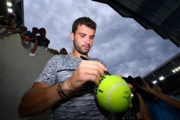 El búlgaro Grigor Dimitrov firma un autógrafo en una pelota de tenis gigante.