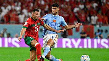 Morocco's midfielder #15 Selim Amallah (L) fights for the ball with Spain's forward #10 Marco Asensio during the Qatar 2022 World Cup round of 16 football match between Morocco and Spain at the Education City Stadium in Al-Rayyan, west of Doha on December 6, 2022. (Photo by JAVIER SORIANO / AFP)