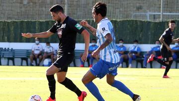 Puertas conduce el balón defendido por Escassi.