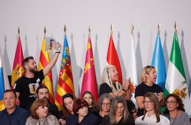 Un hombre sostiene la fotografía de una víctima mientras él y otros increpan al presidente de la Generalitat Valenciana, Carlos Mazón, a quien las víctimas habían pedido que no asistiera debido a la gestión de la catástrofe, el día del funeral de Estado en memoria de las víctimas de las inundaciones de Valencia del año anterior.