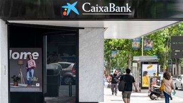 MADRID, SPAIN - 2022/06/20: Pedestrians walk past the Spanish largest savings bank Caixa Bank (CaixaBank) branch in Spain. (Photo by Xavi Lopez/SOPA Images/LightRocket via Getty Images)