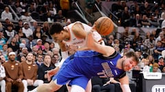 Luka Doncic #77 of the Dallas Mavericks is fouled as he drives past Victor Wembanyama #1 of the San Antonio Spurs in the second half at Frost Bank Center on March 19, 2024 in San Antonio, Texas.